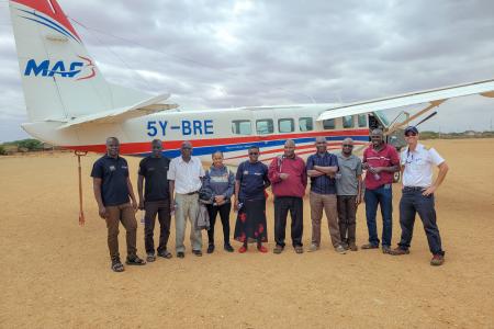 A group of ophthalmologists from the Fred Hollows Foundation pictured alongside Pilot Daniel at Madera Airstrip.