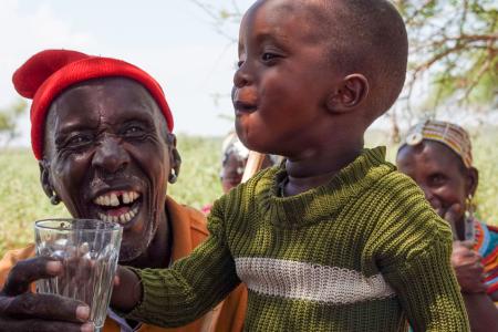 A happy child savors a refreshing glass of clean water.