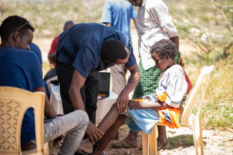 Dr Maluki closely examines a young girls foot during the clinic