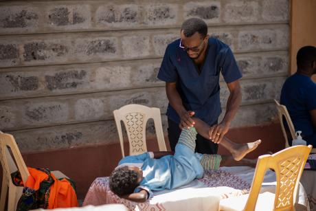 Dr Maluki closely assessing the level of damage on the girl's foot before treatment.