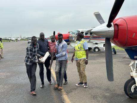 One of the patients is carried to the aircraft in Juba before being airlifted to Wilson airpirt in Nairobi
